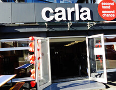 Außenansicht des carla-Shops in Dornbirn bei Tag. ie Außenfassade ist schicht in schwarz gehalten und viele Fenster ziert den etwa 10 Meter langen Shop. Der Schriftzug "carla" wurde über der Türe groß angebracht. 